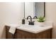 Close-up of a bathroom vanity with a white countertop, oak cabinets, matte black faucet and decorative accents at 427 Wright Way, Henderson, NV 89015