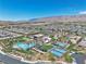Stunning aerial view of the community featuring a pool, clubhouse, tennis and pickleball courts, and desert landscaping at 4277 Sunrise Flats St, Las Vegas, NV 89135