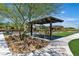Relaxing outdoor area with benches, shade structure, and walking paths in a landscaped community space at 4277 Sunrise Flats St, Las Vegas, NV 89135