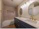 Modern bathroom featuring double sinks, gold fixtures, and a bathtub with tile surround at 5040 Spencer St # D, Las Vegas, NV 89119