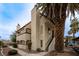 Charming multi-level building featuring stucco walls, a tile roof, and a mature palm tree in a desert landscape at 5040 Spencer St # D, Las Vegas, NV 89119