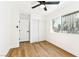 Bright bedroom showcasing wood-look floors, a window, a ceiling fan, and sliding closet doors at 5078 Mountain Vista St, Las Vegas, NV 89120