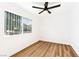 Minimalist bedroom design featuring wood-look floors, a ceiling fan, and a window at 5078 Mountain Vista St, Las Vegas, NV 89120