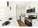 Modern kitchen featuring white cabinets, marble countertops, and stainless steel appliances, with black hardware accents at 5078 Mountain Vista St, Las Vegas, NV 89120