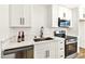Well-equipped kitchen features stainless steel appliances, white marble countertops, and sleek white cabinets at 5078 Mountain Vista St, Las Vegas, NV 89120