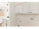 Bright laundry room featuring white cabinetry, sleek hardware, and modern plumbing fixtures at 5078 Mountain Vista St, Las Vegas, NV 89120