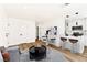 Bright living room with a modern kitchen featuring white cabinets, an island with marble countertops, and stainless steel appliances at 5078 Mountain Vista St, Las Vegas, NV 89120