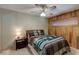 This bedroom includes a full size bed, a ceiling fan, and a wood paneled wall at 5262 Harris Ave, Las Vegas, NV 89110