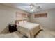 Cozy bedroom with textured wallpaper, ceiling fan, carpet, and two windows providing natural light at 5262 Harris Ave, Las Vegas, NV 89110