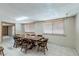 Dining room with a large wood table set for eight, illuminated by natural light from two sizable windows at 5262 Harris Ave, Las Vegas, NV 89110