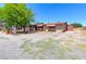 Single-story home featuring a rustic fence and mature trees, nestled on a spacious lot at 5262 Harris Ave, Las Vegas, NV 89110