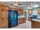 Bright kitchen featuring wood cabinets, black appliances, tile floors, a skylight, and ceiling fans at 5262 Harris Ave, Las Vegas, NV 89110