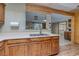 Kitchen featuring wood cabinets, white countertops, tile floors, stainless steel sink, and open to other living spaces at 5262 Harris Ave, Las Vegas, NV 89110
