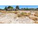 A vacant land for sale with small shrubs and a single-Gathering home in the background at 5262 Harris Ave, Las Vegas, NV 89110