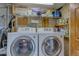 A laundry room with washer, dryer, storage shelves, and wallpaper at 5262 Harris Ave, Las Vegas, NV 89110