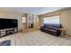 Cozy living room with a brick fireplace, a dark leather sofa, and tile floors at 5262 Harris Ave, Las Vegas, NV 89110