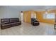 Spacious living room with tile floors, wood paneled walls, and inviting seating arrangements that offer relaxation at 5262 Harris Ave, Las Vegas, NV 89110