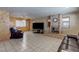Spacious living room featuring a brick fireplace, wood paneling, and tile flooring at 5262 Harris Ave, Las Vegas, NV 89110