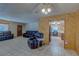 An inviting living room with dark leather sofas, tile floors, and wood paneling adjacent to the kitchen at 5262 Harris Ave, Las Vegas, NV 89110