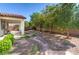 Landscaped backyard with mature trees, covered patio, and gravel ground cover at 5412 Dalle Valley St, North Las Vegas, NV 89031