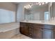 Bathroom featuring a double vanity, soaking tub and glass enclosed shower at 5412 Dalle Valley St, North Las Vegas, NV 89031