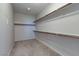 Spacious walk-in closet with built in shelving, neutral carpet, and bright lighting at 5412 Dalle Valley St, North Las Vegas, NV 89031