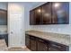 Close up of kitchen cabinets and granite countertops with a white door and stainless steel hardware at 5412 Dalle Valley St, North Las Vegas, NV 89031