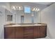 Bathroom featuring dual sinks with granite counters, modern lighting, and large mirrors at 5852 Brown Tree Ln, North Las Vegas, NV 89081