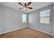 A carpeted bedroom with a ceiling fan and two windows providing natural light at 5852 Brown Tree Ln, North Las Vegas, NV 89081