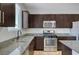 Modern kitchen features granite countertops, stainless steel appliances, and dark wood cabinets at 5852 Brown Tree Ln, North Las Vegas, NV 89081