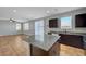 Modern kitchen with dark cabinetry, granite counters, stainless appliances, and an adjacent sunny living area at 5852 Brown Tree Ln, North Las Vegas, NV 89081