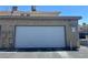 Exterior shot of attached garage at 6420 Little Pine Way, featuring a white door and neutral facade at 6420 Little Pine Way, Las Vegas, NV 89108