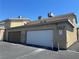 Exterior shot of garages at Little Pine Way, showing a white door and a brown door side by side at 6420 Little Pine Way, Las Vegas, NV 89108