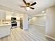 Open floor plan features new gray flooring and a modern kitchen with stainless steel appliances and white cabinets at 6420 Little Pine Way, Las Vegas, NV 89108
