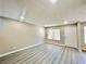 Bright living room featuring new gray flooring and modern neutral wall paint with a front door entrance at 6420 Little Pine Way, Las Vegas, NV 89108