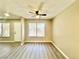 Living room with ceiling fan, neutral paint, new gray flooring and natural lighting from the front windows at 6420 Little Pine Way, Las Vegas, NV 89108