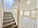 A staircase leads to a bright living room with vinyl floors and natural lighting from a window at 6420 Little Pine Way, Las Vegas, NV 89108