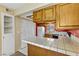 Functional kitchen with white tile countertops, bright lighting, and a range of essential appliances, offering a practical cooking space at 721 Bourbon St # F2, Pahrump, NV 89048