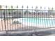 Fenced in-ground pool viewed through an iron decorative security fence at 721 Bourbon St # F2, Pahrump, NV 89048