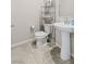 Cozy bathroom featuring a pedestal sink, toilet, and shelving for storage at 7819 Rachelis St, North Las Vegas, NV 89084