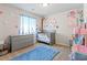 Charming Bedroom with crib, dresser, and decorative floral accents, creating a sweet space at 7819 Rachelis St, North Las Vegas, NV 89084