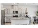 Updated kitchen with stainless steel appliances, granite countertops, and gray cabinets at 7819 Rachelis St, North Las Vegas, NV 89084