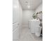 Neat laundry room with a washer, dryer, tile flooring, and an open shelf at 7819 Rachelis St, North Las Vegas, NV 89084