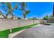 Large backyard with a block wall, manicured artificial lawn, and covered patio at 8250 Lincoln Valley St, Las Vegas, NV 89123
