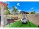 Outdoor living is easy with the inviting backyard swing and dining area on artificial turf at 8250 Lincoln Valley St, Las Vegas, NV 89123