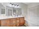 Bathroom featuring a double sink vanity, soaking tub, and large mirrors at 8250 Lincoln Valley St, Las Vegas, NV 89123