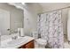 Standard bathroom featuring a single sink vanity, toilet and shower with curtain at 8250 Lincoln Valley St, Las Vegas, NV 89123