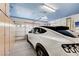 View of garage with epoxy flooring, built-in storage, and a white car parked inside at 8250 Lincoln Valley St, Las Vegas, NV 89123