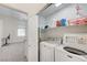 Bright laundry room with washer, dryer, and additional shelving at 8250 Lincoln Valley St, Las Vegas, NV 89123