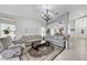 Spacious living room featuring tile flooring, neutral walls, and a stylish chandelier at 8250 Lincoln Valley St, Las Vegas, NV 89123